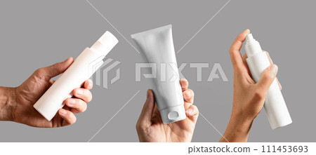 White blank cream tube, spray lotion bottle, cosmetic pack mockup in male hand set isolated on white White blank cream tube, spray lotion bottle, cosmetic pack mockup in male hand set isolated on white 111453693