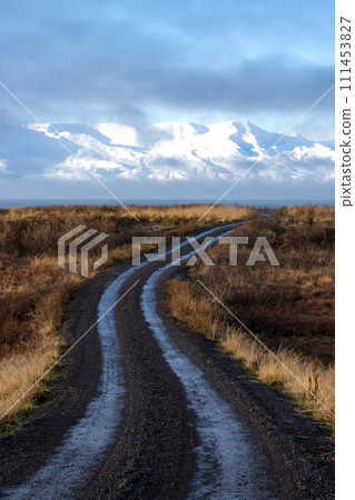 Road across a field and mountains, Iceland Road across a field and mountains, Iceland 111453827