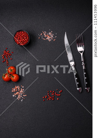 Salt, allspice, cherry tomatoes with copy space on a dark concrete background 111453996