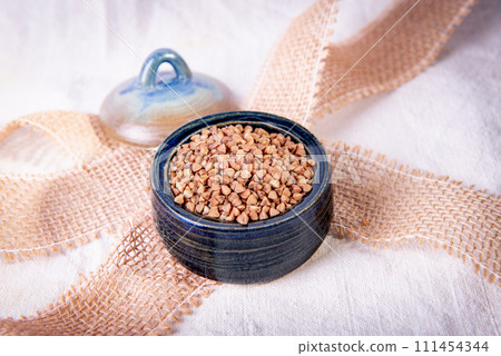 Bowl with raw uncooked buckwheat, Raw Buckwheat Pile, Dry Buck Wheat Grains, Uncooked Buckwheat 111454344