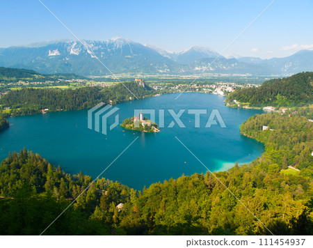 Aerial view of Bled Lake with island church and Bled Castle, mountains in background, Slovenia 111454937