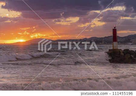 Golden Sunset Casting Warm Hues Over a Coastal Cityscape and Beacon Golden Sunset Casting Warm Hues Over a Coastal Cityscape and Beacon 111455196