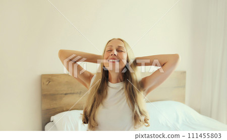 Healthy sleep, relaxed middle aged woman wakes up on the bed at home Healthy sleep, relaxed middle aged woman wakes up on the bed at home 111455803