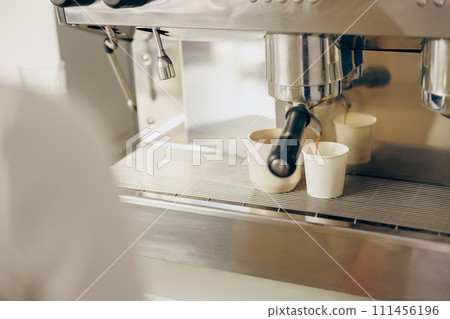 Coffee machine filling a two cups with espresso in professional coffee shop Coffee machine filling a two cups with espresso in professional coffee shop 111456196