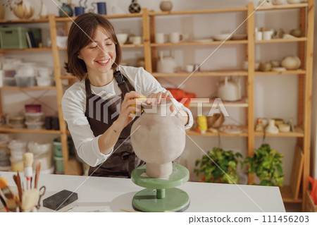 Professional female ceramist work with unfired clay vase in pottery studio. High quality photo Professional female ceramist work with unfired clay vase in pottery studio. High quality photo 111456203