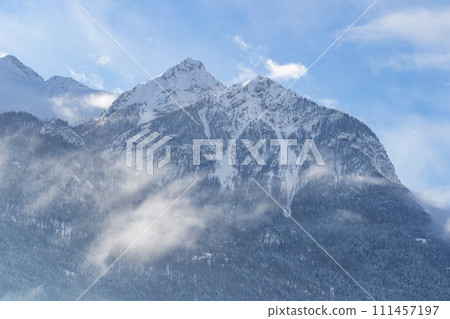 Mountain covered with snow and fog. Alpine landscape in Italy, Europe. Snow-capped mountains Mountain covered with snow and fog. Alpine landscape in Italy, Europe. Snow-capped mountains 111457197