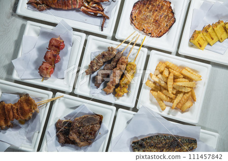 Grilled meat on skewers with french fries on a white plate 111457842