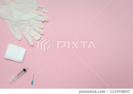 Flat lay of syringes, gauze, and latex gloves on a pink background Flat lay of syringes, gauze, and latex gloves on a pink background 111459607