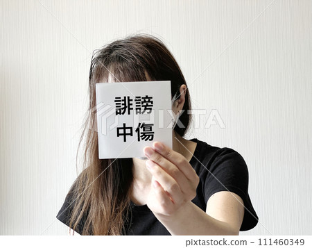 一名婦女一手舉著一張寫有誹謗性文字的紙條。 一名婦女一手舉著一張寫有誹謗性文字的紙條。 111460349