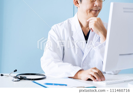 Male doctor examining the electronic medical record 111460716