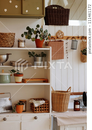 A kitchen with a shelf filled with potted plants and baskets 111461172