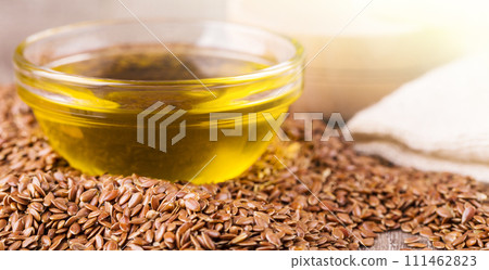 Brown flax seeds and flaxseed oil on a wooden surface 111462823