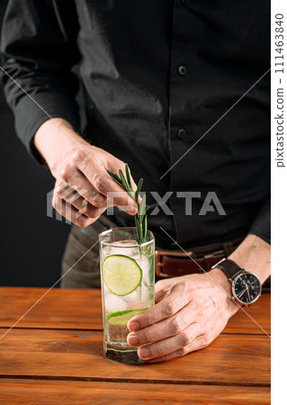 Man making fresh gin tonic cocktail with lime 111463840