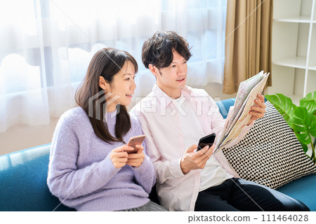 一個男人和一個女人用地圖和智慧型手機交談 一個男人和一個女人用地圖和智慧型手機交談 111464028
