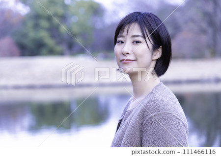 一個女人在公園裡的水邊提神 111466116