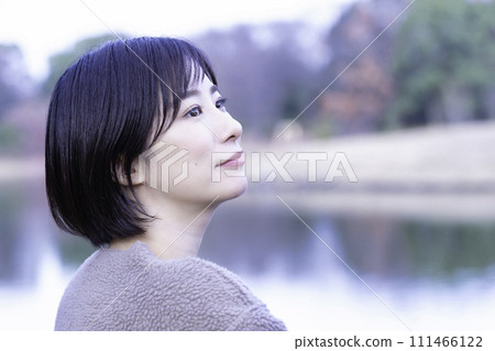 A woman refreshing herself by the water in the park A woman refreshing herself by the water in the park 111466122