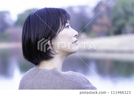 A woman refreshing herself by the water in the park A woman refreshing herself by the water in the park 111466123