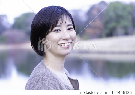 一個女人在公園裡的水邊提神 111466126