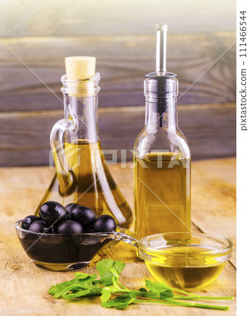 Olive oil with fresh herbs and Black olives on the wooden background 111466544