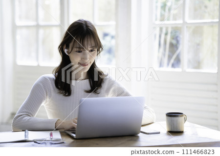 A woman having an online meeting in a bright room A woman having an online meeting in a bright room 111466823