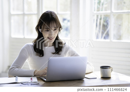 A woman having an online meeting in a bright room A woman having an online meeting in a bright room 111466824