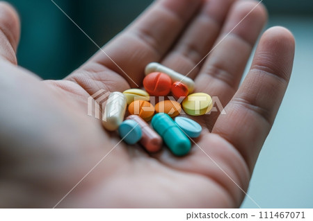 Close up view of hand holding a heap of multicolored variety of pills and capsules Close up view of hand holding a heap of multicolored variety of pills and capsules 111467071