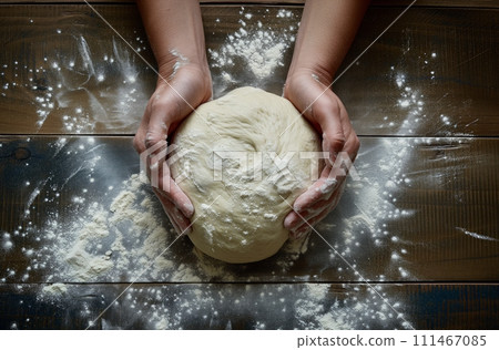 Top view of pair of hands kneading dough in the kitchen on a wooden table Top view of pair of hands kneading dough in the kitchen on a wooden table 111467085