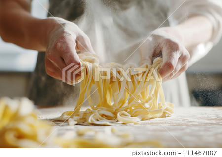 Close up view of hands making fresh italian pasta on wooden kitchen table Close up view of hands making fresh italian pasta on wooden kitchen table 111467087