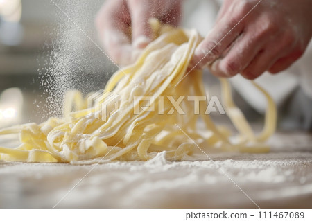 Close up view of hands making fresh italian pasta on wooden kitchen table 111467089