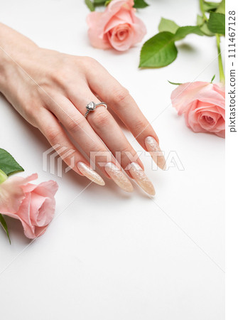 Female Hands on a white background with beautiful pearl manicure.Hands on a brown background and beautiful pearl manicure Female Hands on a white background with beautiful pearl manicure.Hands on a brown background and beautiful pearl manicure 111467128