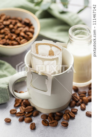 Drip coffee bag with ground coffee in  cup 111467142