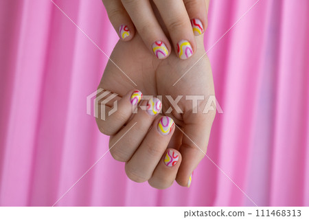 Stylish colorful summer female nails on pink background. Modern trendy stylish Beautiful manicure. Cute pastel nail minimalistic design concept of beauty treatment. Gel nails. Skin care 111468313