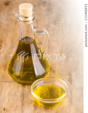 Extra virgin healthy Olive oil on wooden background on sunlight Extra virgin healthy Olive oil on wooden background on sunlight 111468851