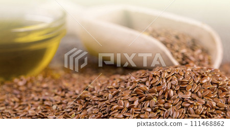 Brown flax seeds and flaxseed oil on a wooden surface on soft sunlight 111468862