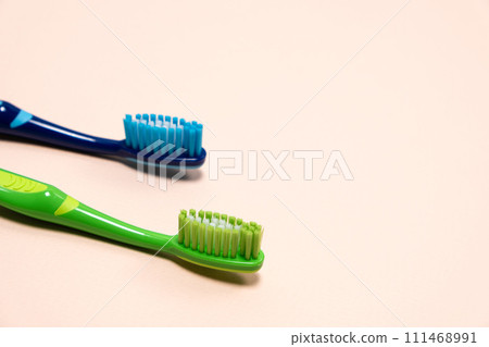 Two toothbrushes on a beige background, copy space for text. Two toothbrushes on a beige background, copy space for text. 111468991