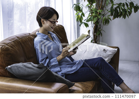 Middle-aged woman reading on the sofa Middle-aged woman reading on the sofa 111470097