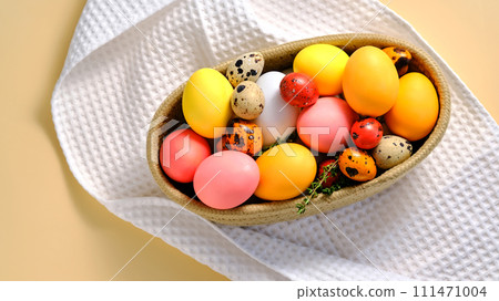 Easter colored eggs in a wicker basket. Easter composition. 111471004