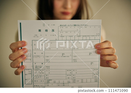 A woman in her 30s presents her husband with divorce papers A woman in her 30s presents her husband with divorce papers 111471090