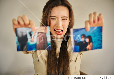 一名 30 多歲的婦女拿著她外遇的照片證據與丈夫對峙 一名 30 多歲的婦女拿著她外遇的照片證據與丈夫對峙 111471198