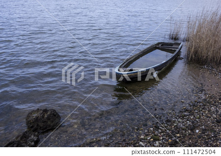 Lakeside landscape with a broken ship 111472504