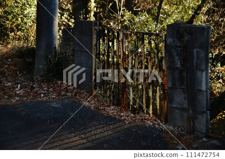 Rusty gate illuminated by the setting sun Rusty gate illuminated by the setting sun 111472754
