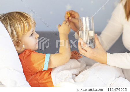 Toddler Receiving Medicine from Mother in Bed 111474925