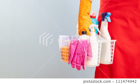 Person Holding Basket with Cleaning Supplies and Wearing Gloves 111474942