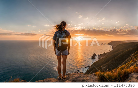 Girl with backpack standing atop a cliff overlooking a vast ocean captured 111475386