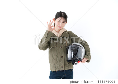 A woman holding a helmet and giving an OK sign A woman holding a helmet and giving an OK sign 111475994