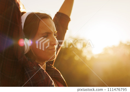 Woman Enjoying Sunset with Headphones Woman Enjoying Sunset with Headphones 111476795