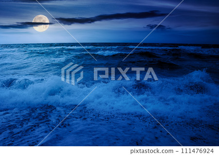 dramatic seascape at night. waves crashing on the beach in full moon light dramatic seascape at night. waves crashing on the beach in full moon light 111476924
