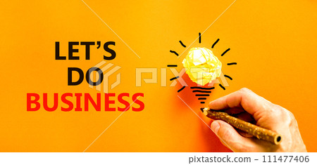 let is do business symbol. Concept words let is do business on beautiful orange paper. Beautiful orange background. Light bulb icon. Businessman hand. let is do business concept. Copy space. 111477406