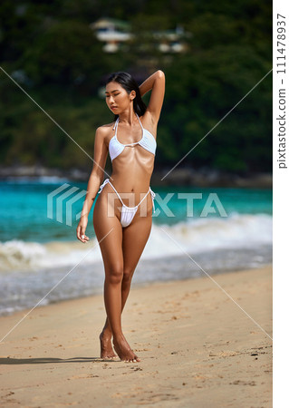 Beautiful asian girl in white bikini posing at the tropical beach 111478937