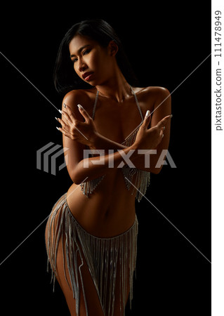 Naked asian girl in transparent dress with rhinestones on threads isolated on the black background Naked asian girl in transparent dress with rhinestones on threads isolated on the black background 111478949